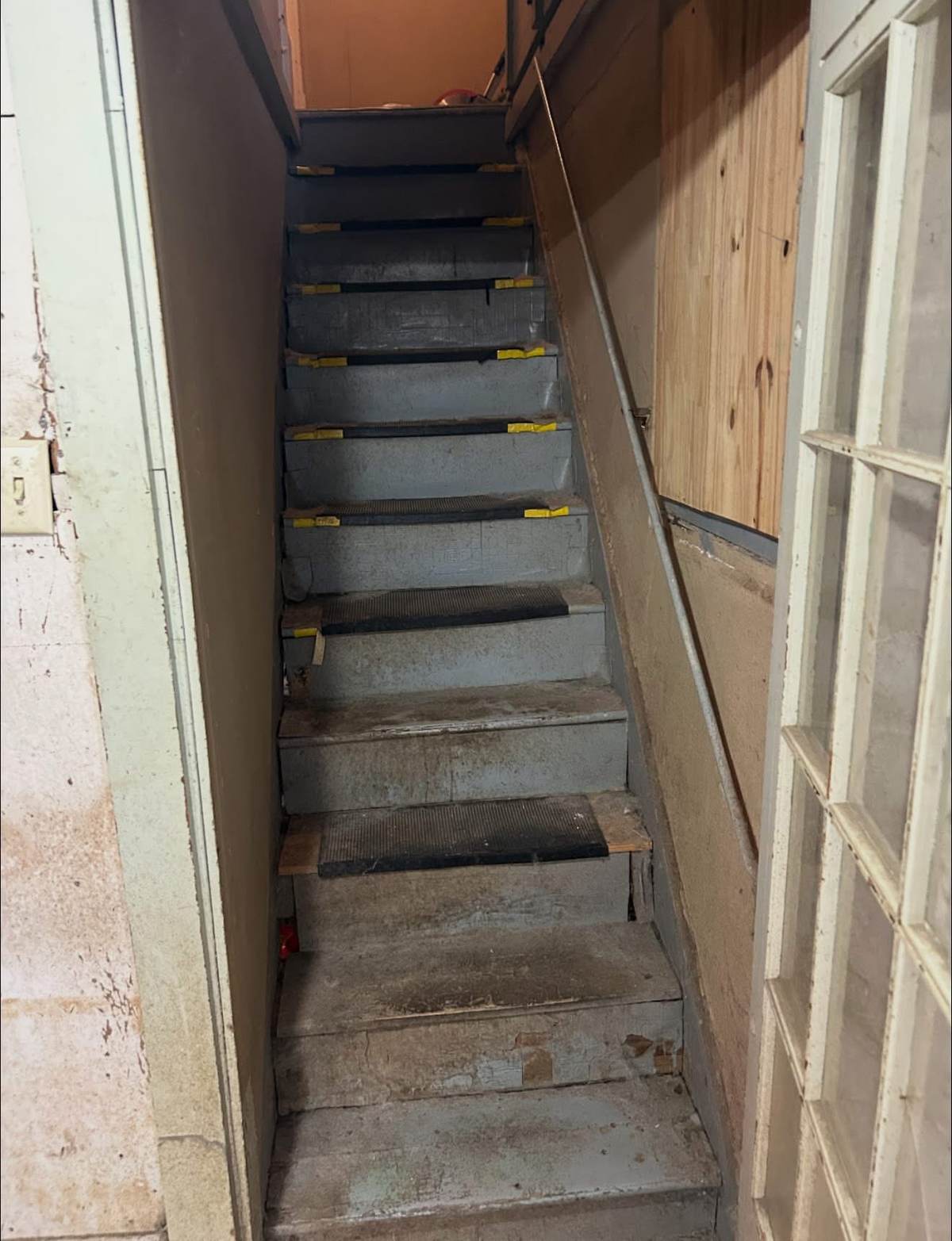 Worn, damaged interior staircase before repair