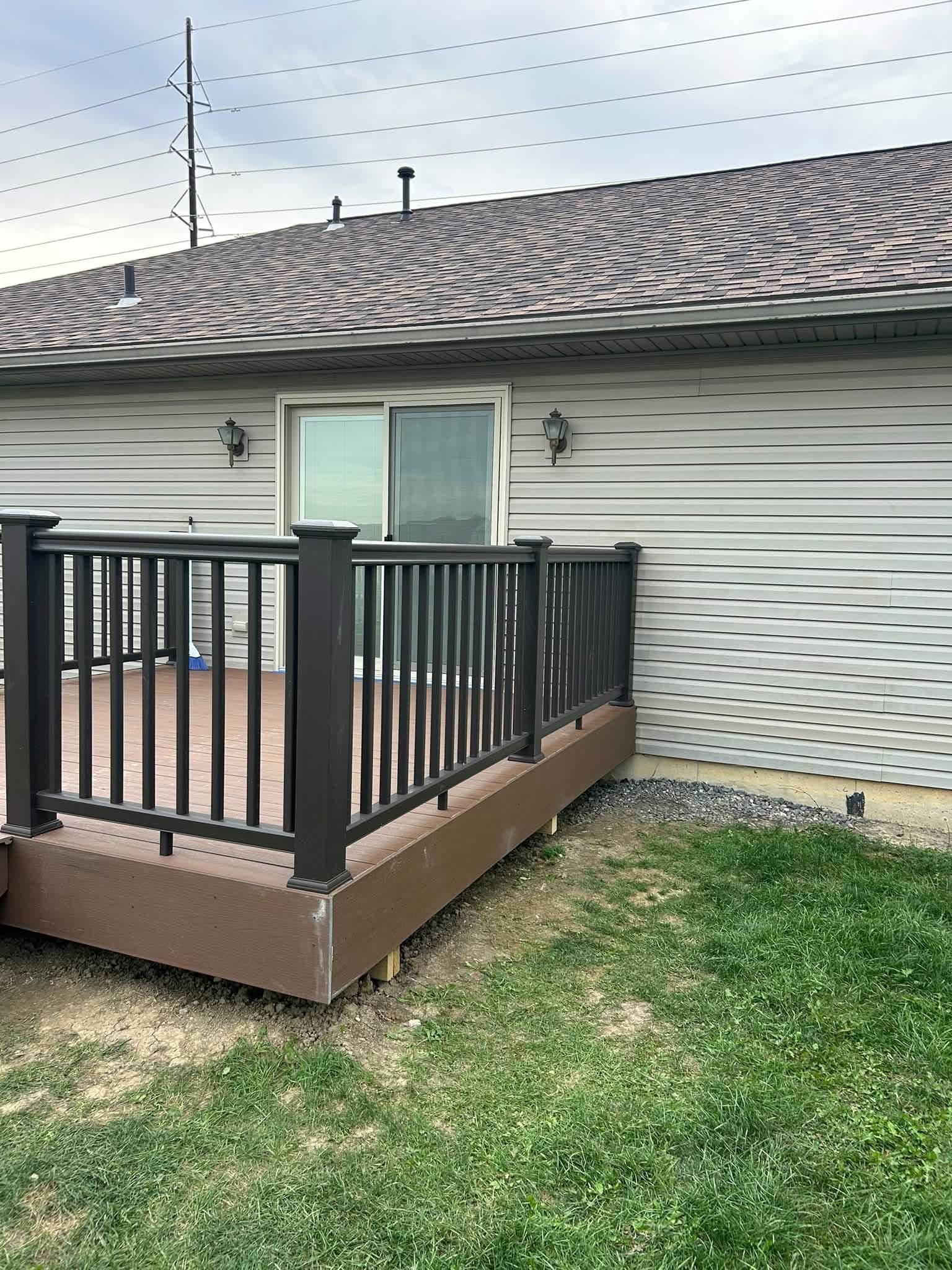 Finished composite deck with black railings built by Corner Construction Company