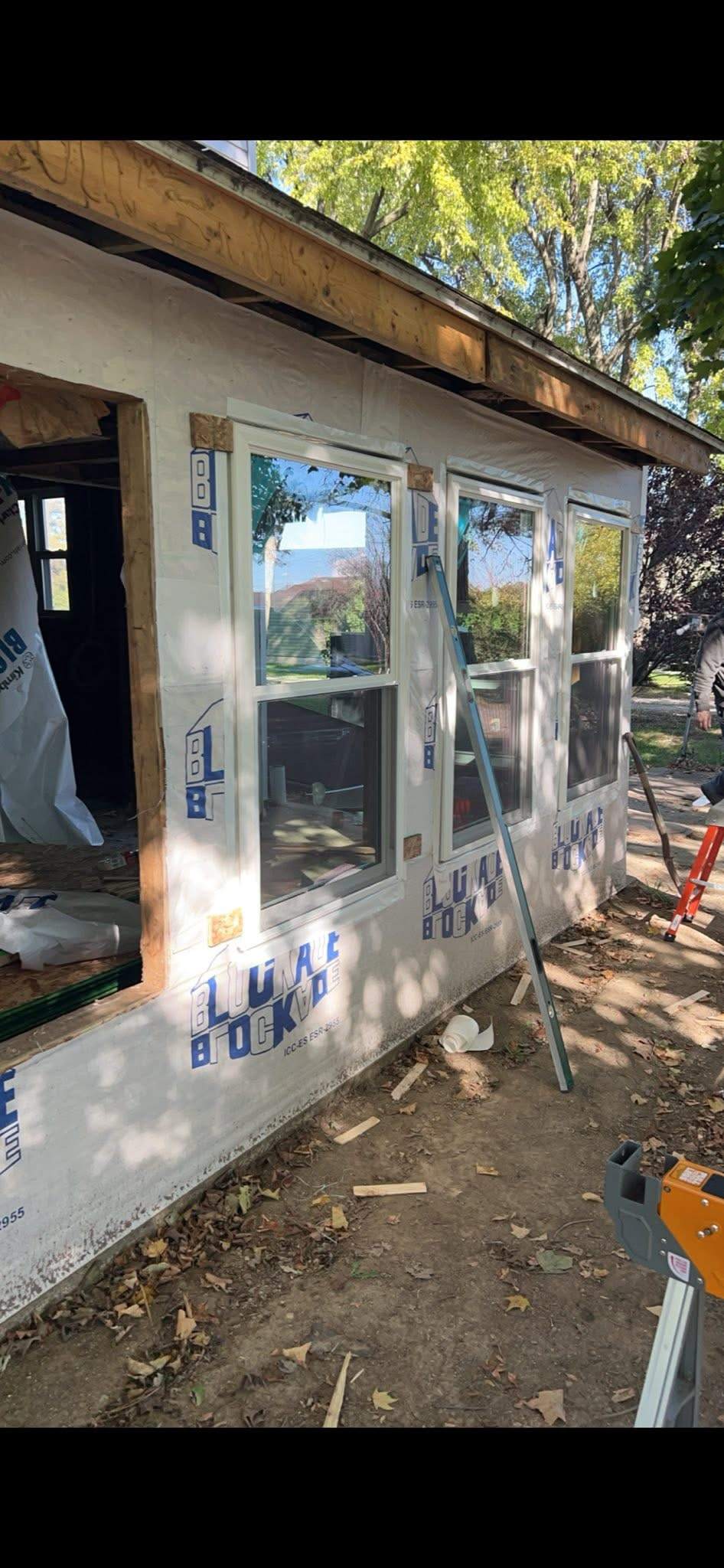 Home addition under construction with new windows and house wrap